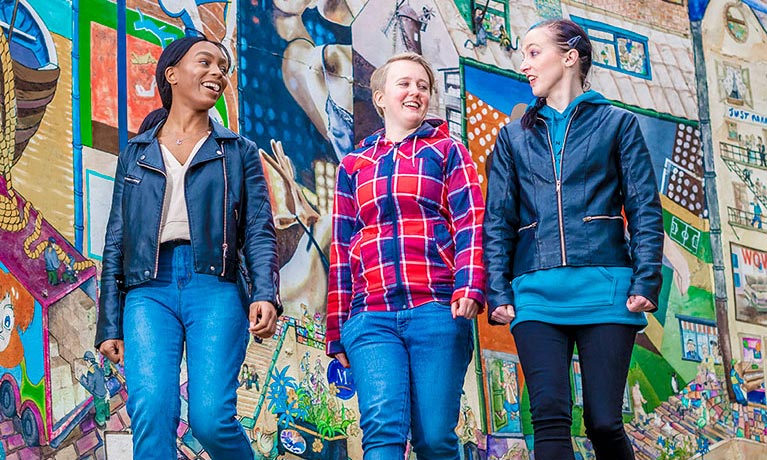 Three students walking down a street