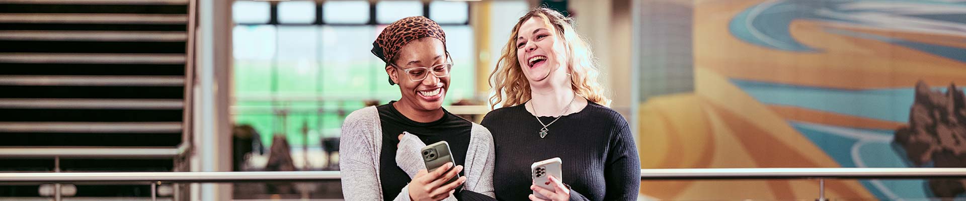Two students walking together and laughing