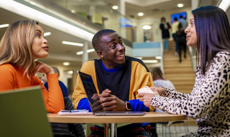 Female and male student looking at a MAC screen