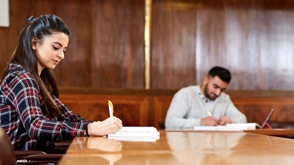 Two Professional Accounting students working at a table in a study hall