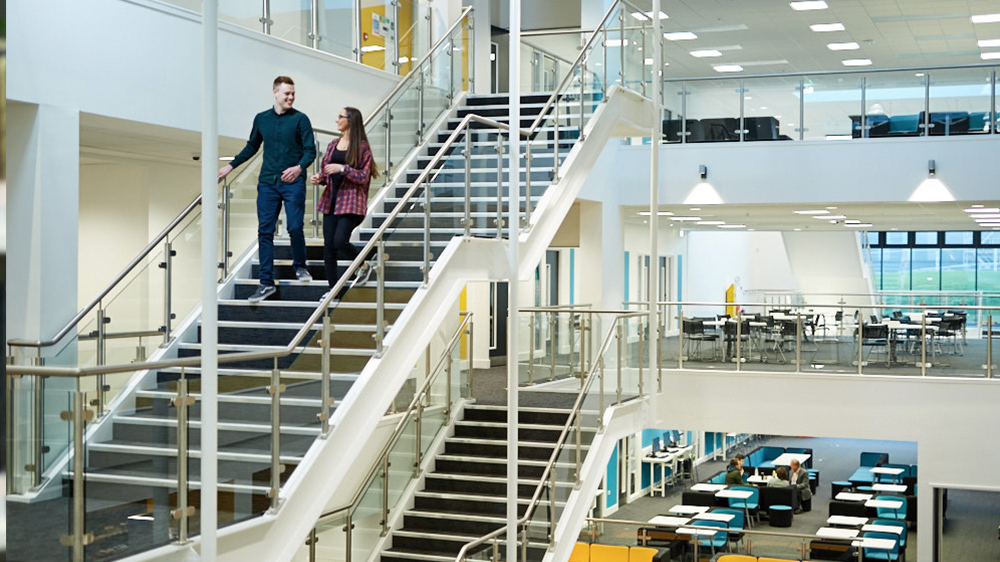 Two Business Management & Leadership students walking down stairs in CU Scarborough campus
