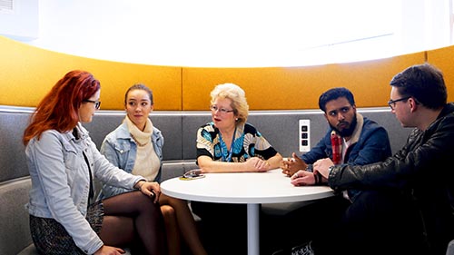 Business students debating around a table