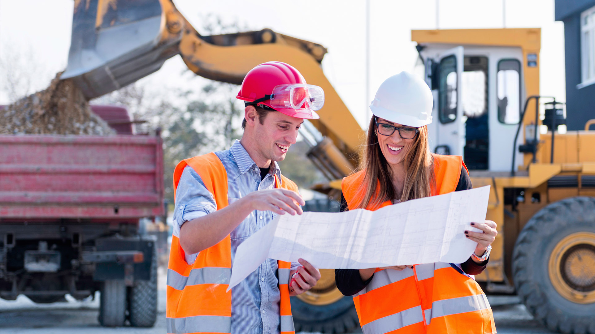 Two Civil Engineering students examining blueprints at a buildin site