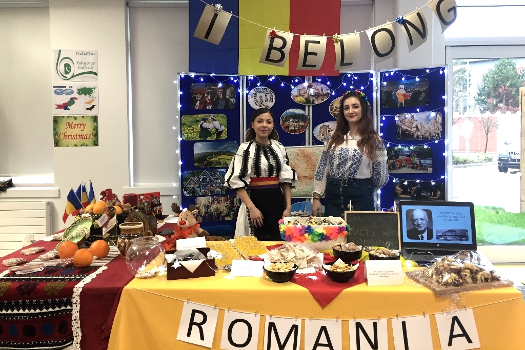 Two female tourism and hospitality students showcasing work on Romania