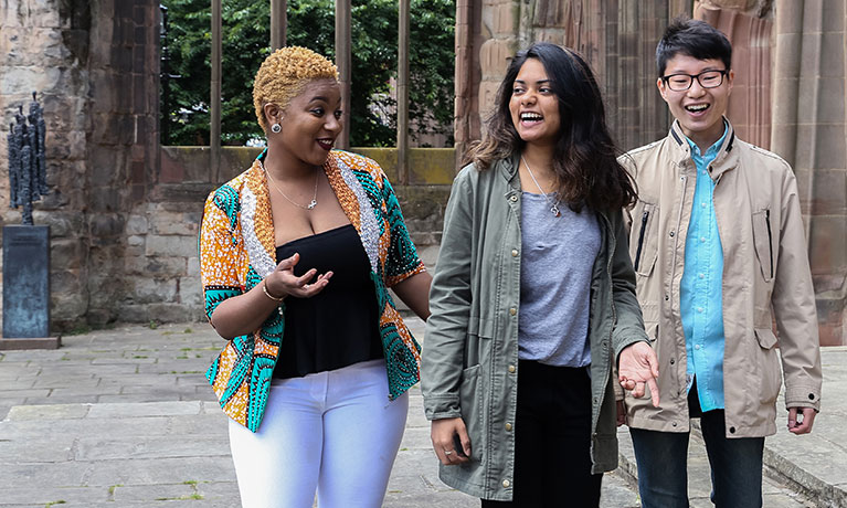 Three students walking and laughing