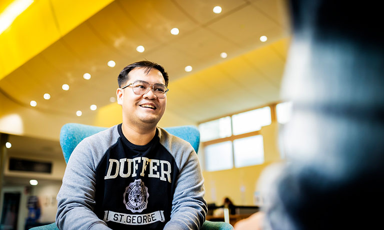 Male student leaning forward and smiling