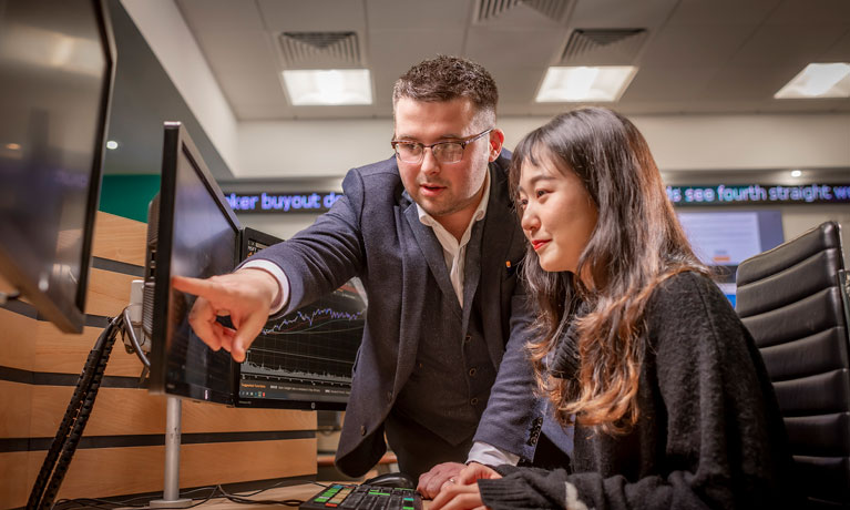 Male teacher explaining graphics to a student