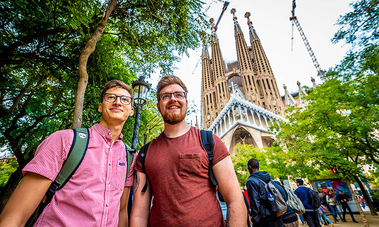 two men standing outside by a cathedral