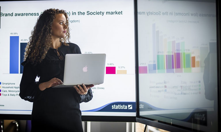 female delivering a presentation holding a laptop