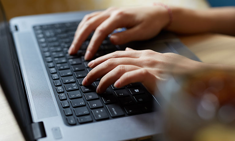 Close up of hands typing on laptop keyboard