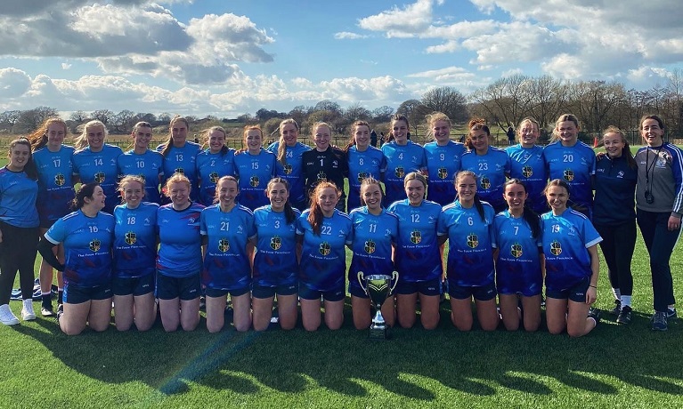Coventry University Ladies Gaelic Football team lined up with the British University Championship trophy and smiling at the camera