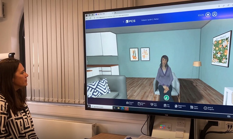 PhD student Juliana Samson looking at a screen showing the virtual patient which is a woman sat in a chair