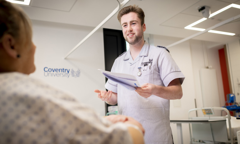 Male nurse talking to patient in hospital