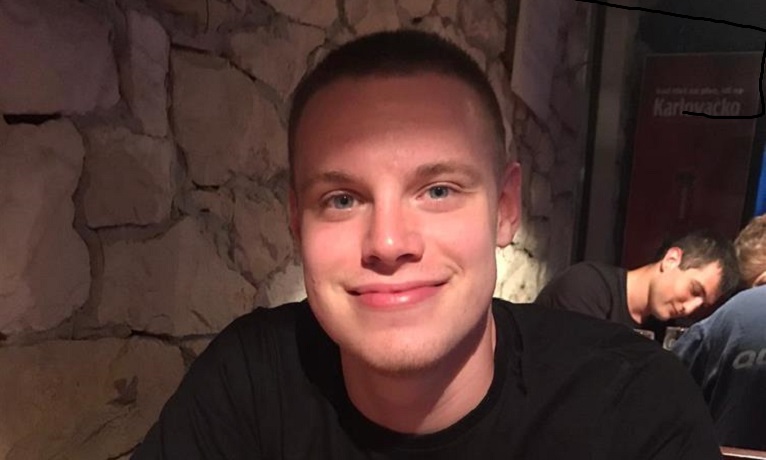 Harry Horton-Walsh looking at the camera and smiling while wearing a black T-shirt