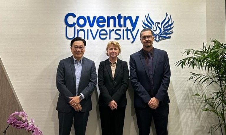 Michael Yap, Ann-Marie Cannaby and Craig Blyth stood in a room with the Coventry University logo behind them