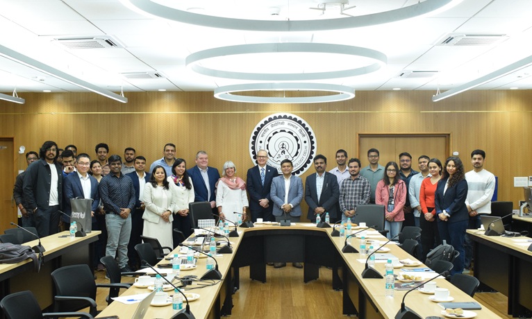 Group shot of Coventry University's delegation alongside representatives of IIT Delhi in a boardroom smiling at the camera