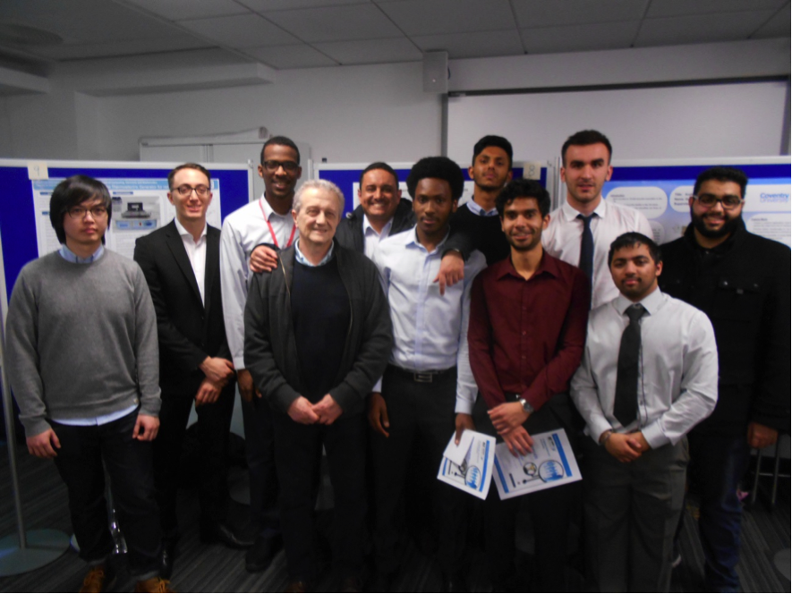 A group of people in front of poster board presentations