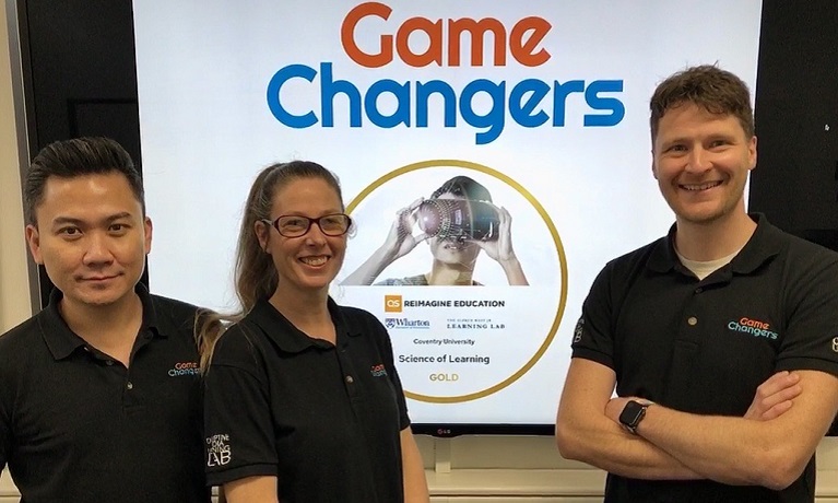 Three members of University staff in front of Gamechangers logo.