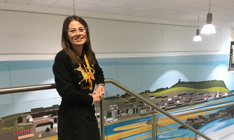 Sophie Pickard leaning on a bannister smiling at the camera