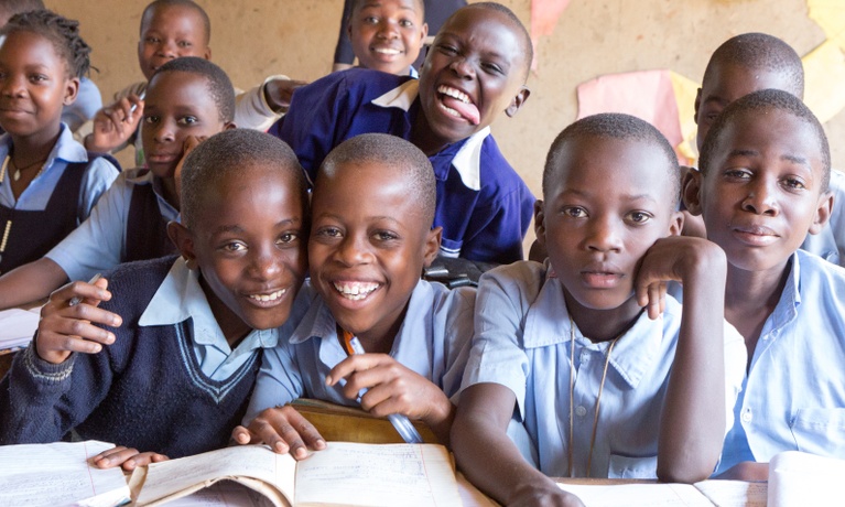Group of school children in uniform smiling at the camera