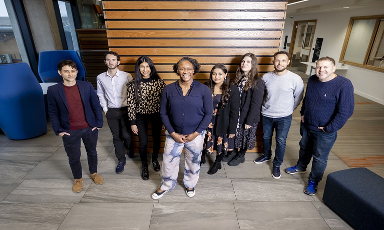 A group shot of eight success coaches in the reception of a university building.