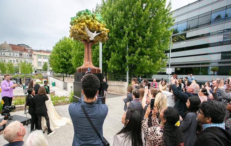 Crowd looks on at 'Tree of Hands' sculpture