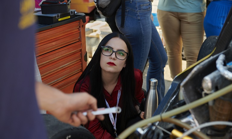 Coventry University student Ines Marokovic, next to an engine looking up at someone out of shot