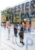 The Lanchester Gallery window signage, with pedestrians seen in the glass reflection