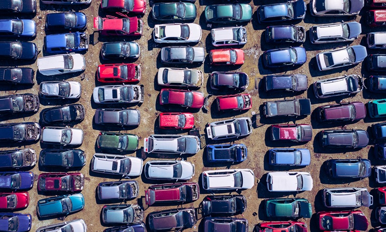 An aerial view of cars lined up in a scrapyard