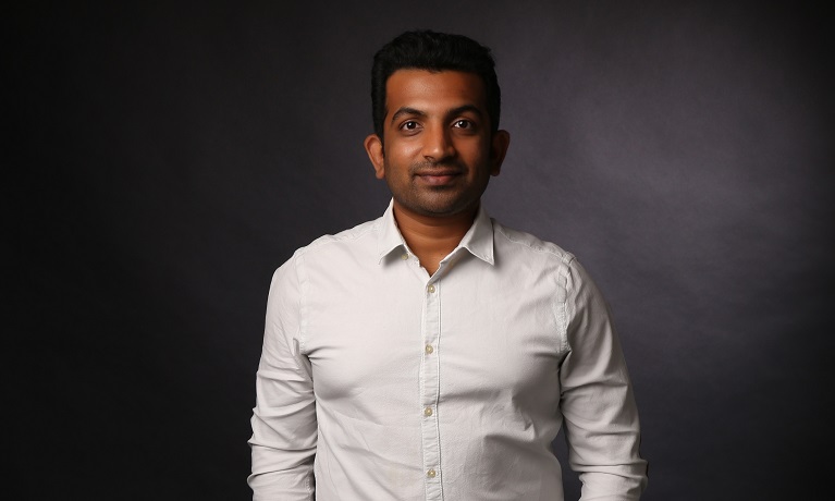 Pratik Shelar wearing a white shirt in front of a dark background