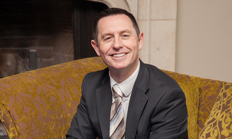A head and shoulders image of Geraint Jones, Chief Executive Officer and Associate-Pro-Vice-Chancellor of NITE, who is wearing a suit, shirt and tie