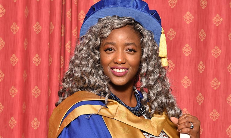 Woman in ceremonial robes holding a certificate