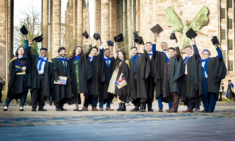 Group of Coventry graduates on steps of cathedral