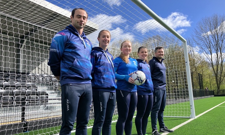 A group of students and staff standing in the goal at the new 3G pitch