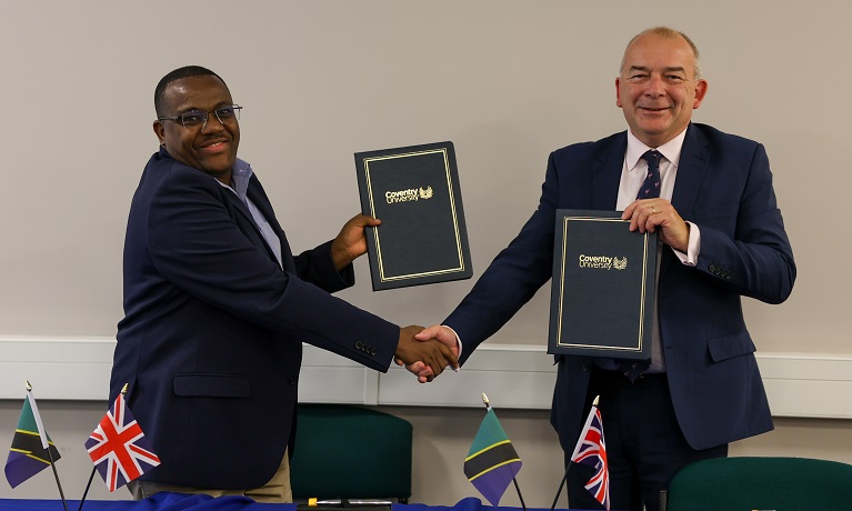 Two men shaking hands holding folders