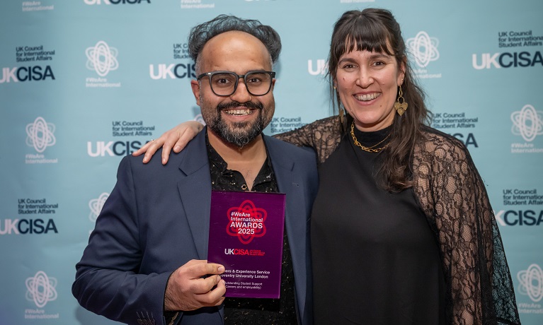 Two people holding an award
