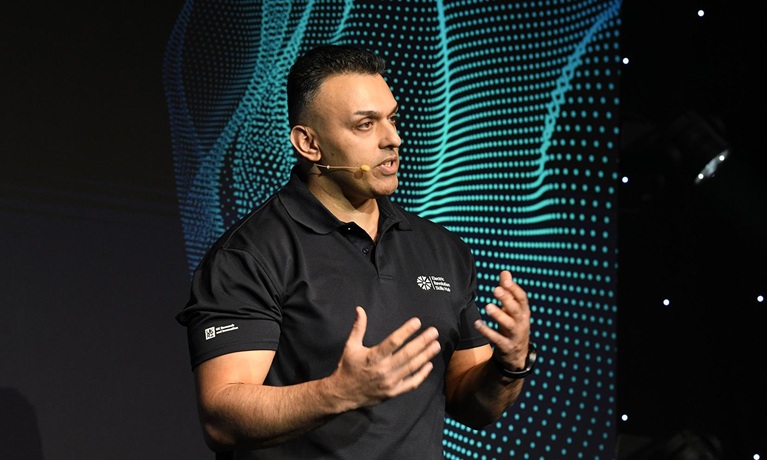 Deepak Farmah wearing a black t-shirt and gesturing with his hands