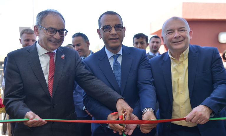 Three men cutting a ribbon at an opening ceremony