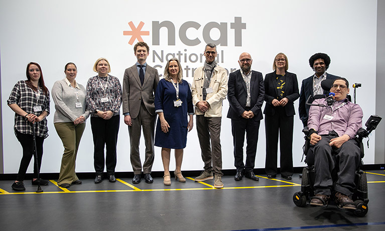 A group picture of the NCAT consortium group in front of the NCAT logo