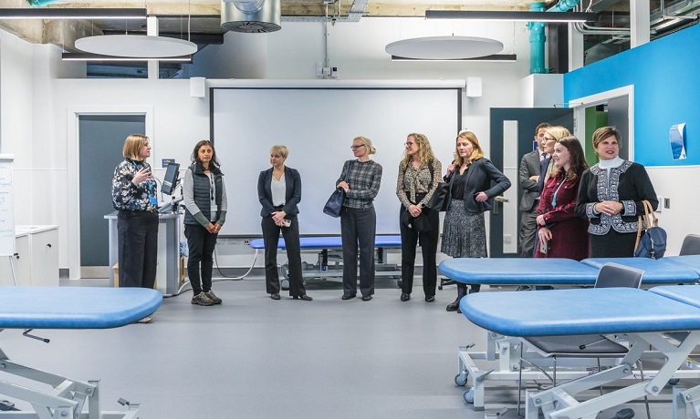 A group of people touring the facilities at the new School of Nursing Midwifery and Health
