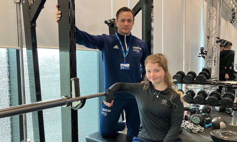 Lecturer Thomas Hames and student Hollie Simpson next to exercise equipment