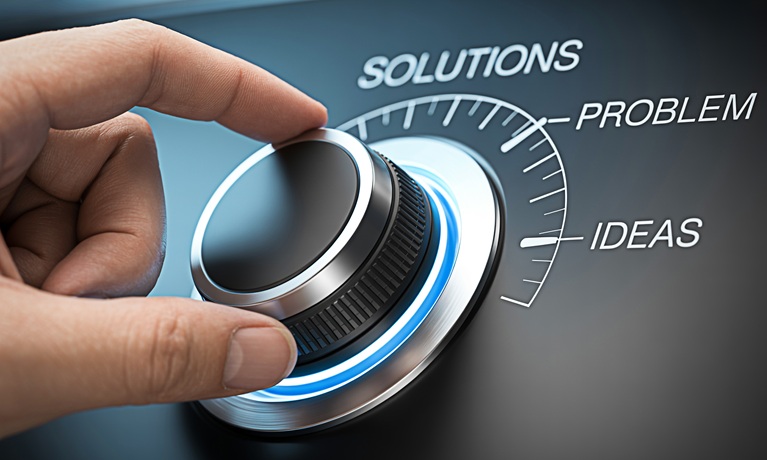 A hand turning a dial between the words 'ideas', 'problem' and 'solutions'.
