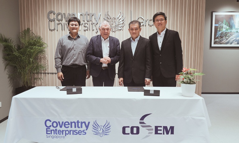 Representatives of Coventry Enterprises (Singapore) and COSEM stood behind a table at the MoU signing