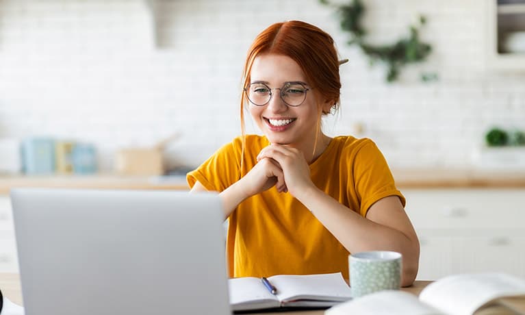 woman smiling infront of a laptop