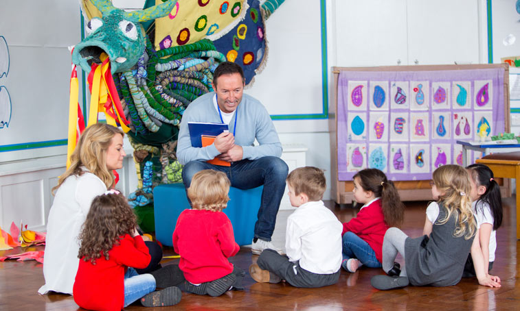 a group of children sat around a teacher, ready to read a book