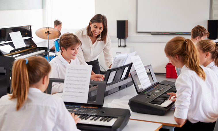 Secondary pupils with keyboards in a music lesson