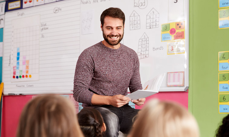 A male teacher at the front of a classroom