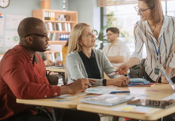 A diverse group of multiethnic young and senior adults working together around a large table.