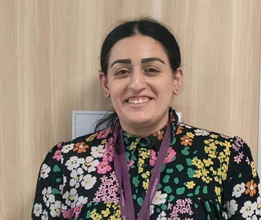 Fatima Khan smiling at her school in a brightly coloured top