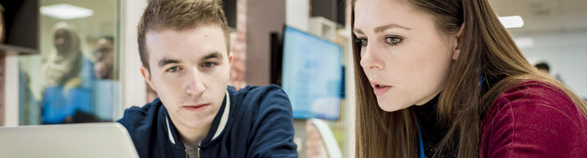 Student and teacher looking at laptop